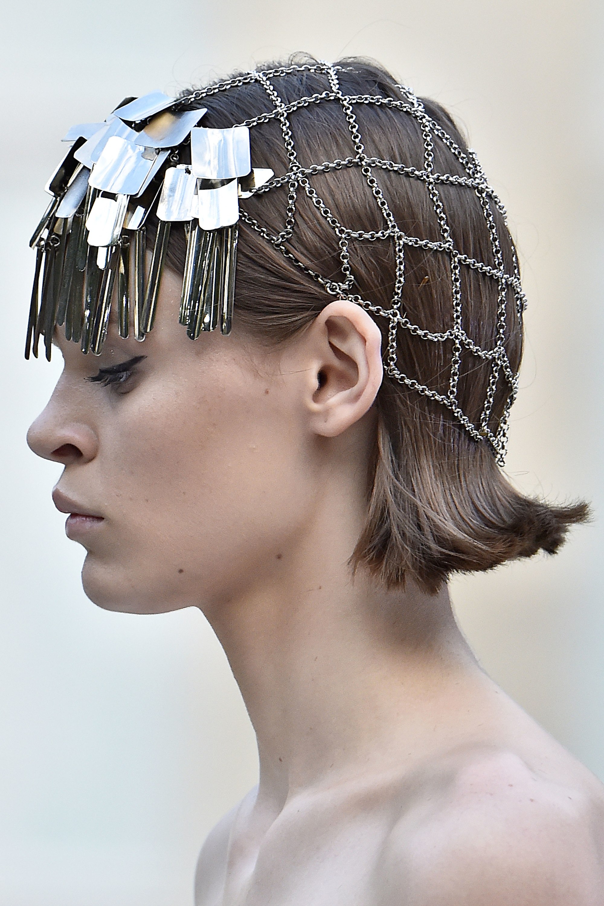 Paris Haute Couture Week fw18: close up shot of a model with flipped light brown bob, wearing hair accessories over it, backstage at the Givenchy haute couture week