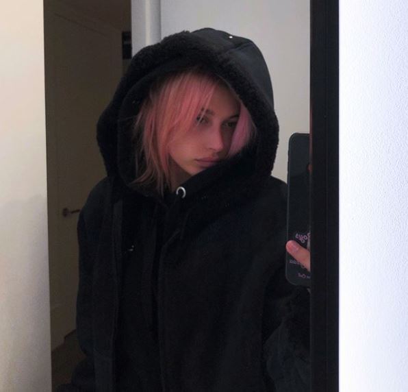 mirror selfie of hailey baldwin with grunge pink hair under black hoodie