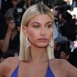 straight short hairstyle: close up shot of hailey baldwin with straight, sleek hair, wearing blue top and posing on the red carpet