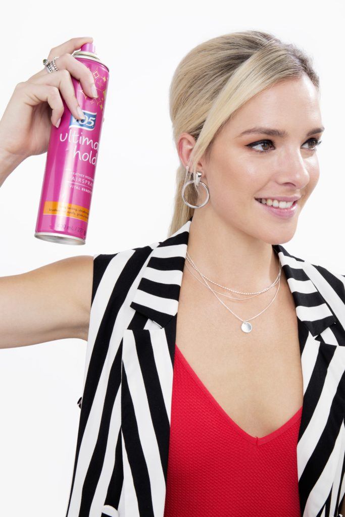 a beautiful blonde woman spraying her long hair