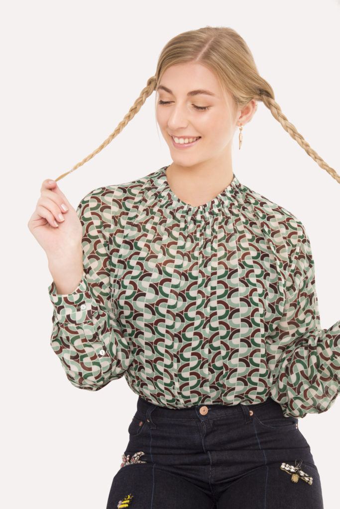 Braided updo blonde girl with braided pigtails looking down and smiling