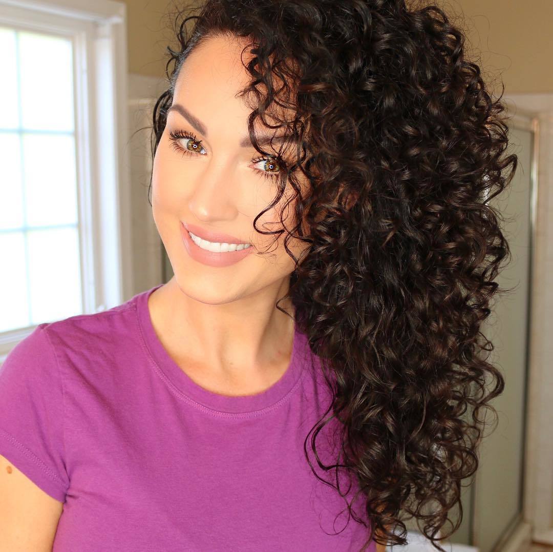 Hair plopping brunette girl smiling with voluminous curly hair