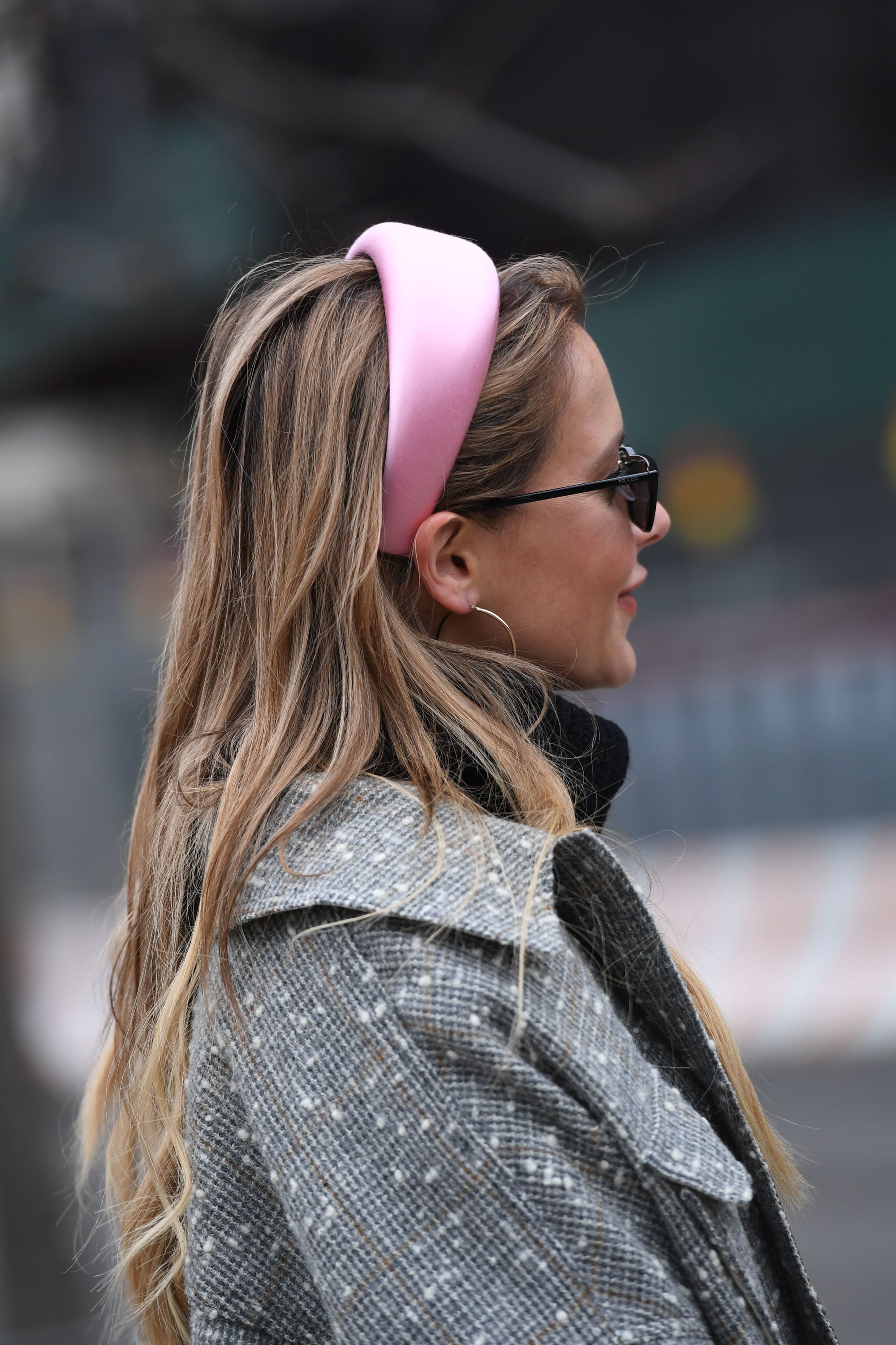 Hair trends 2019: Street style woman with long dirty blonde hair wearing a satin pink headbands and sunglasses.
