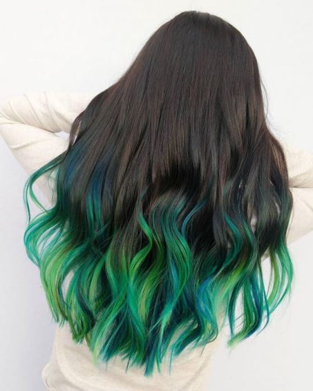 back view of woman with long wavy dark green ombre hair