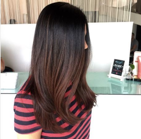 side view of woman with long dark brown ombre hair