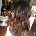 side view of woman with dark brown wavy medium length ombre hair