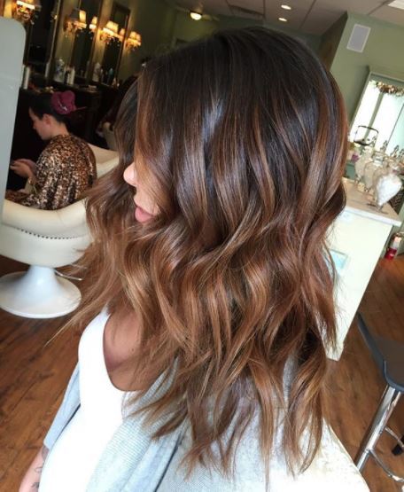 side view of woman with dark brown wavy medium length ombre hair
