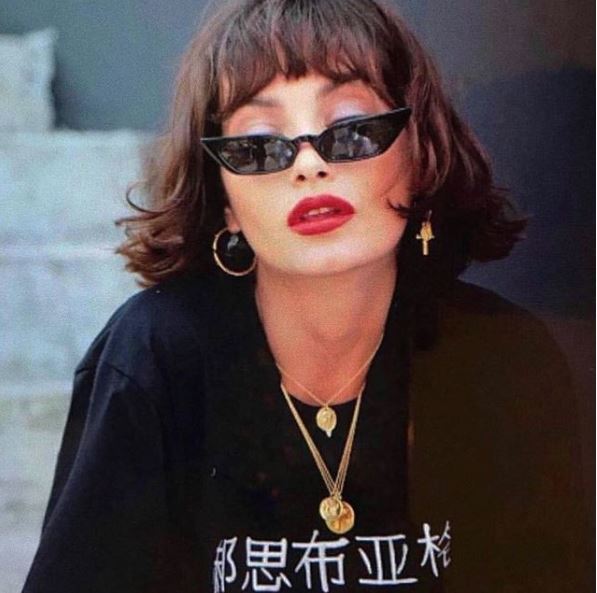 woman with brown hair bob and bangs with micro sunglasses