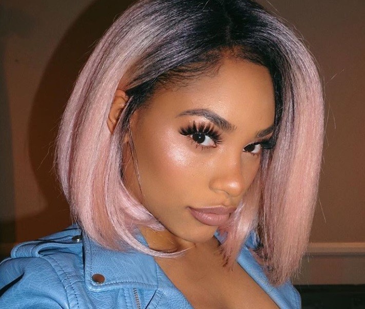 close up shot of itsmyrayeraye with pink bob hairstyle, wearing blue leather jacket and posing for Instagram