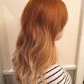 side view of a woman with light copper ombre wavy hair