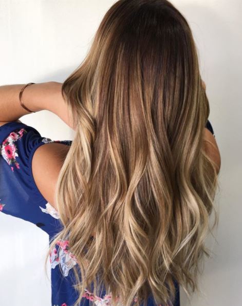 back view of woman with long wavy brown balayage hair