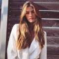 2019 haircut predictions: Woman with long light brown highlighted hair with long layers wearing a white blazer.