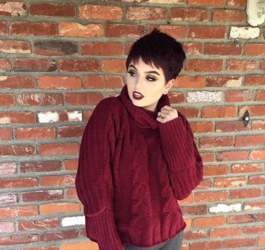 woman with mauve dark pixie hair in a burgundy jumper
