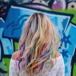 back view of a blonde woman with rainbow hair chalk