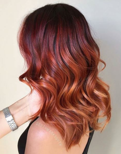 side view of red copper wavy ombre hair