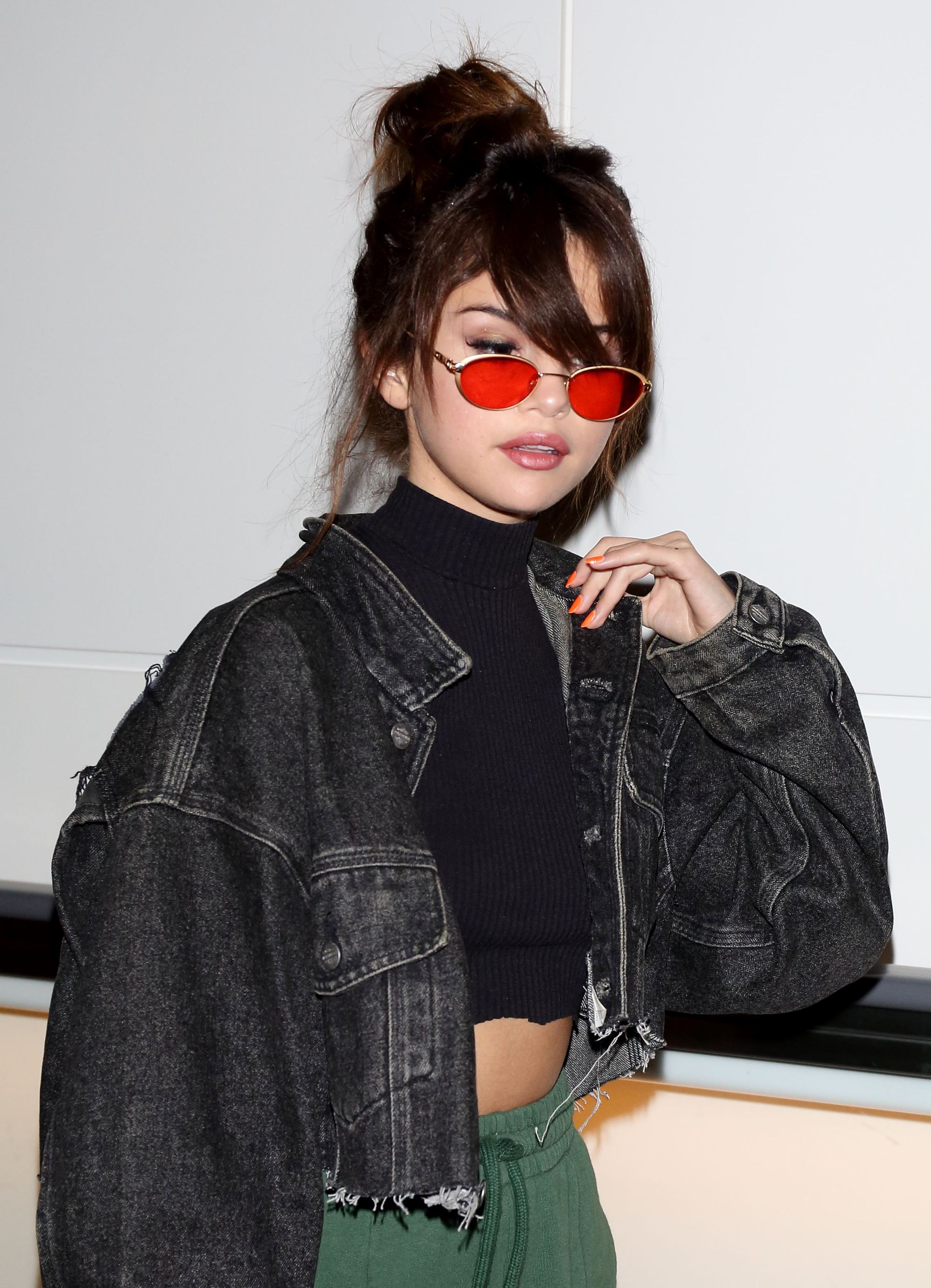 selena gomez brown hair high bun with side fringe