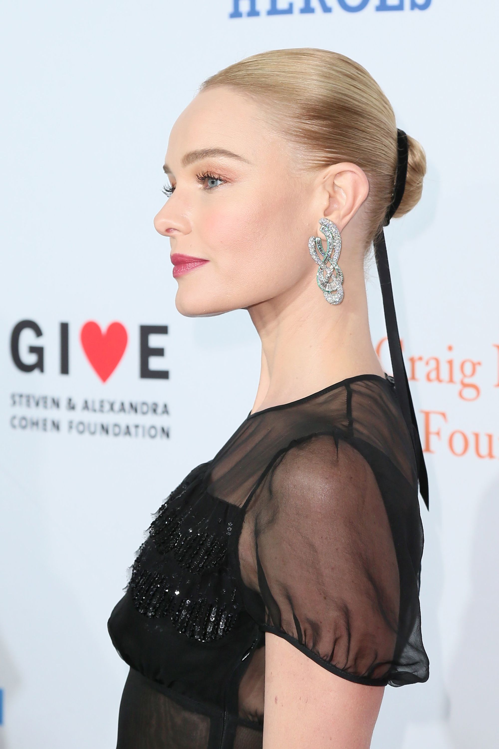 close up shot of kate bosworth with sleek short hair, wearing a ribbon hair accessory and posing on the red carpet