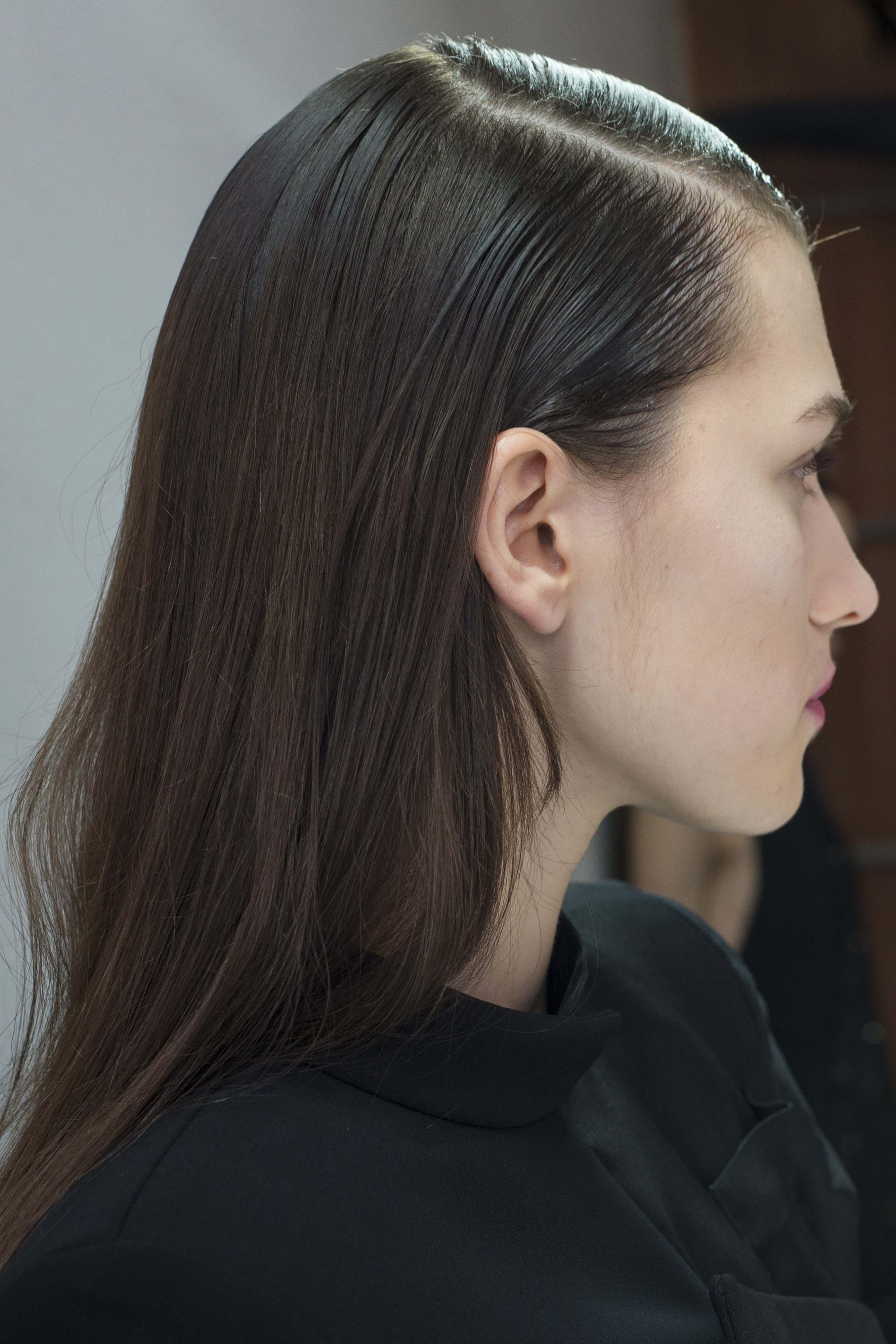 What is dandruff? Girl with brunette hair profile shot with deep side parting