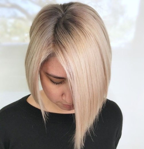 woman with a line ash blonde hair with dark shadow roots