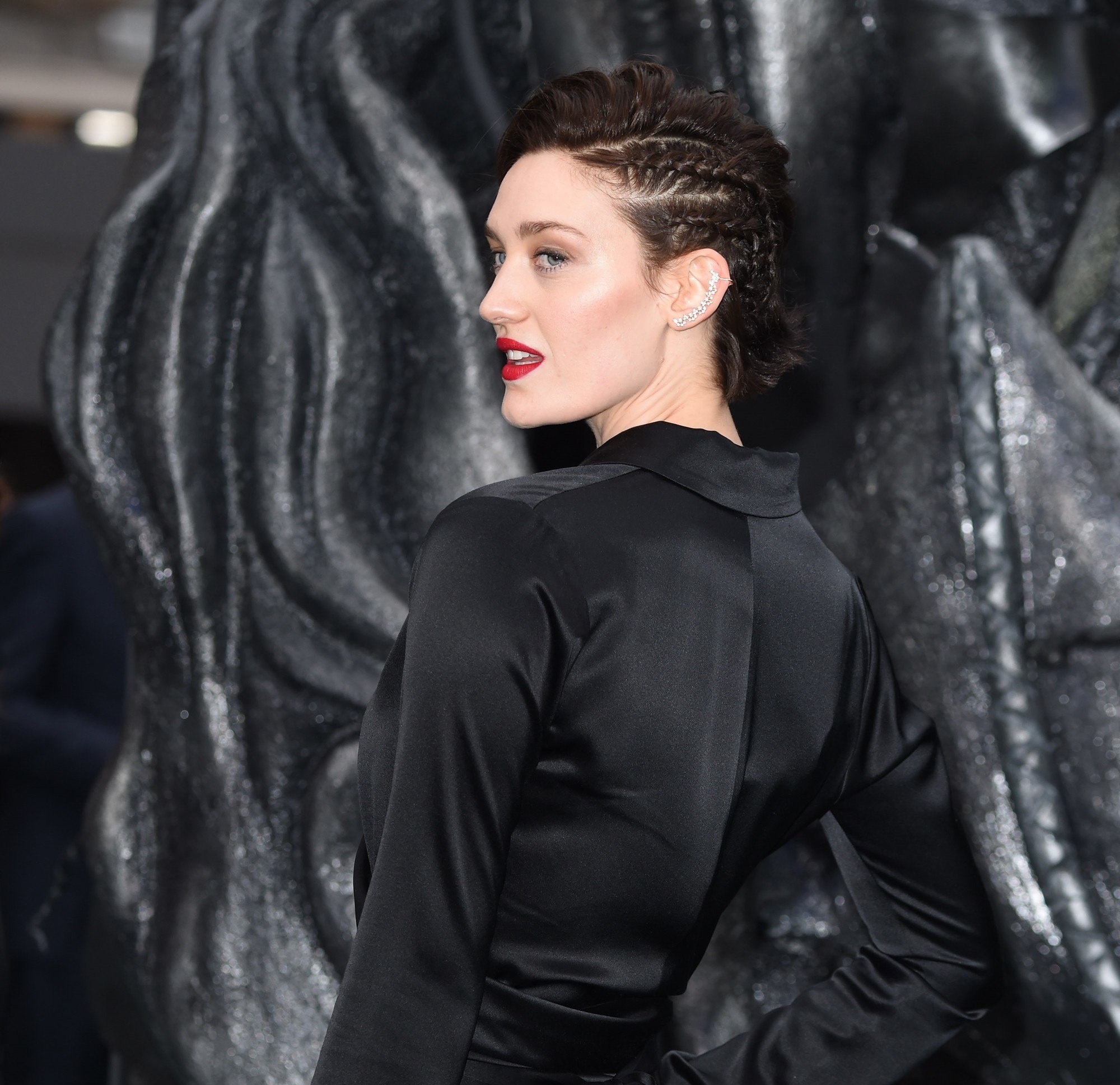 close up shot of tess haubirch with long pixie hairstyle with side braids in it, wearing all black on the red carpet
