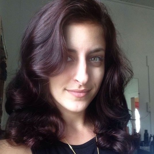 woman with shoulder length curled violet purple hair