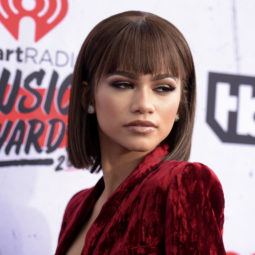 black hair bobs: close up shot of zendaya with scarface inspired bob hairstyle, wearing red velvet dress on the iHeartRadio Music Awards arrivals red carpet