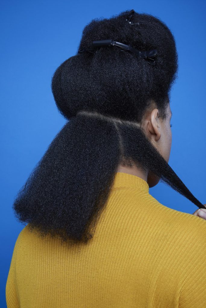 Flexi rods on natural hair girl with back to camera sectioning her hair