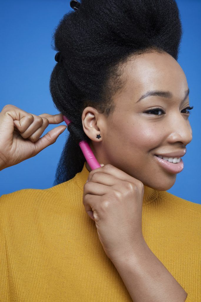 Black woman with afro hair applying flexi rods