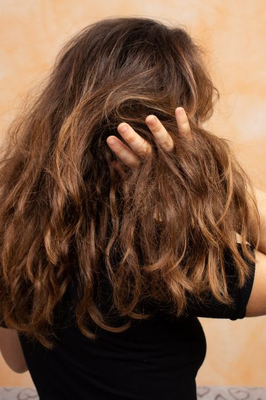 Woman with dry hair touching it
