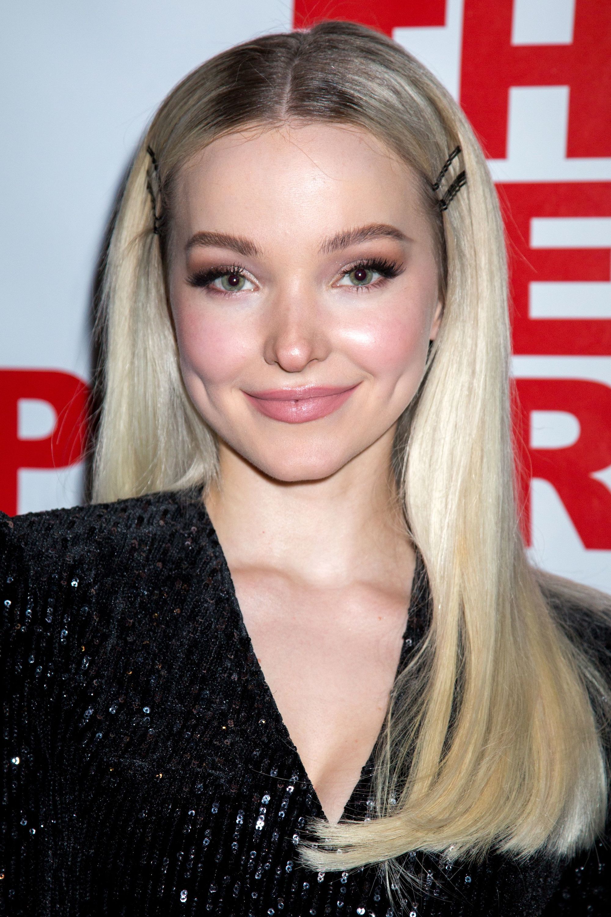 Sexy hairstyles for long hair: Dove Cameron with long straight blonde hair with a centre parting and hair clips