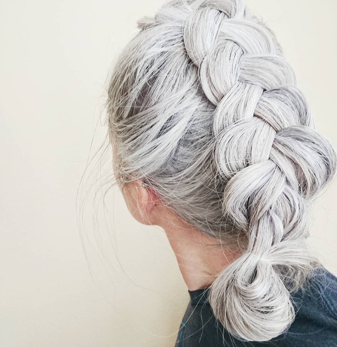 What causes grey hair woman with panckake braid close up