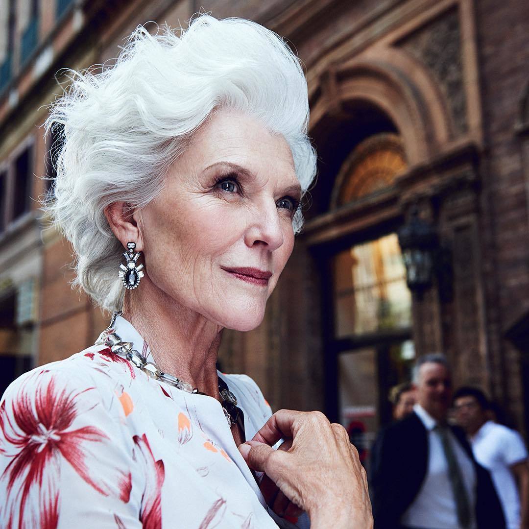 What causes grey hair Maye Musk standing outside in the street