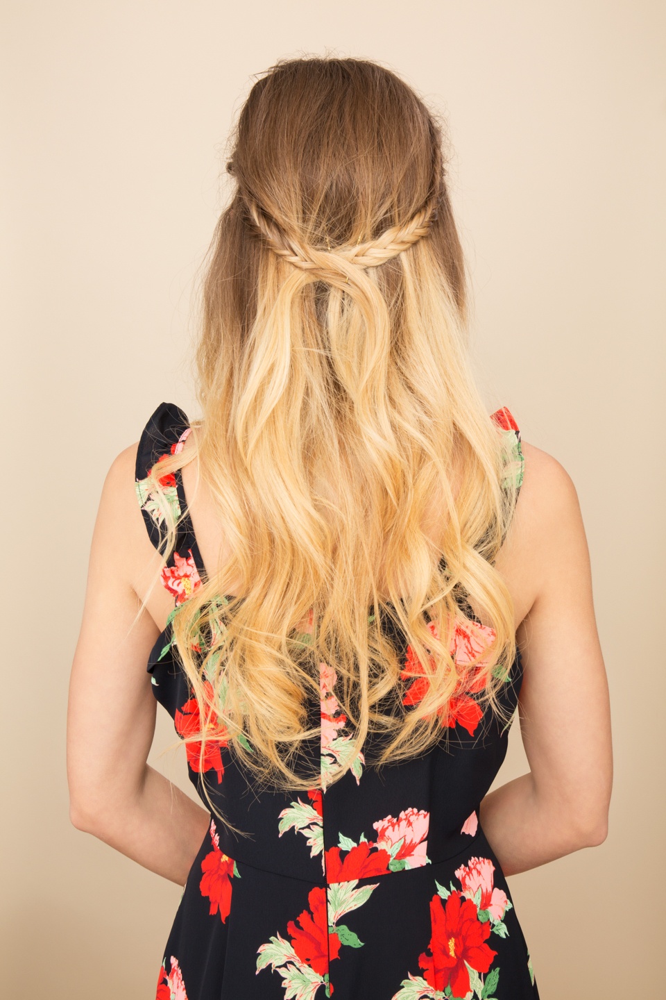cute hairstyles for long hair for school: close up shot of woman with half up braids, wearing floral dress and posing in a studio