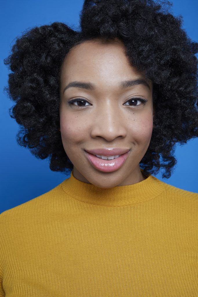 Black girl with flexi rods created short curls smiling at camera