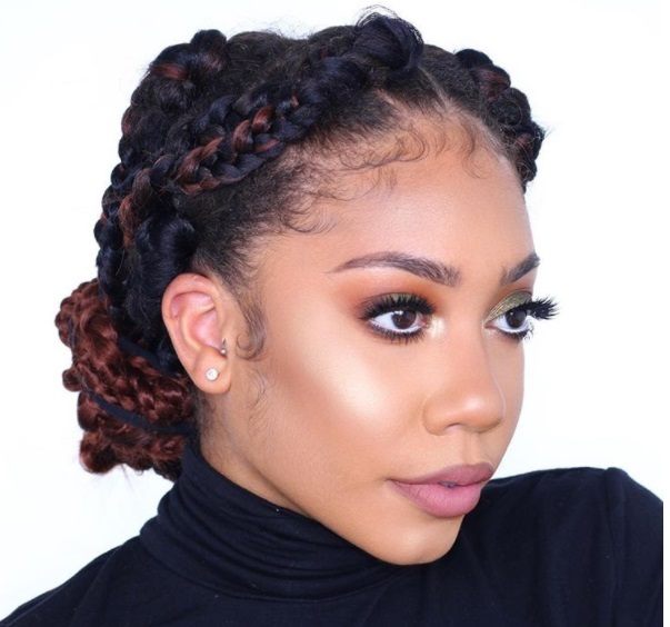 close up shot of woman with low box braids updo hairstyle, wearing all black and posing