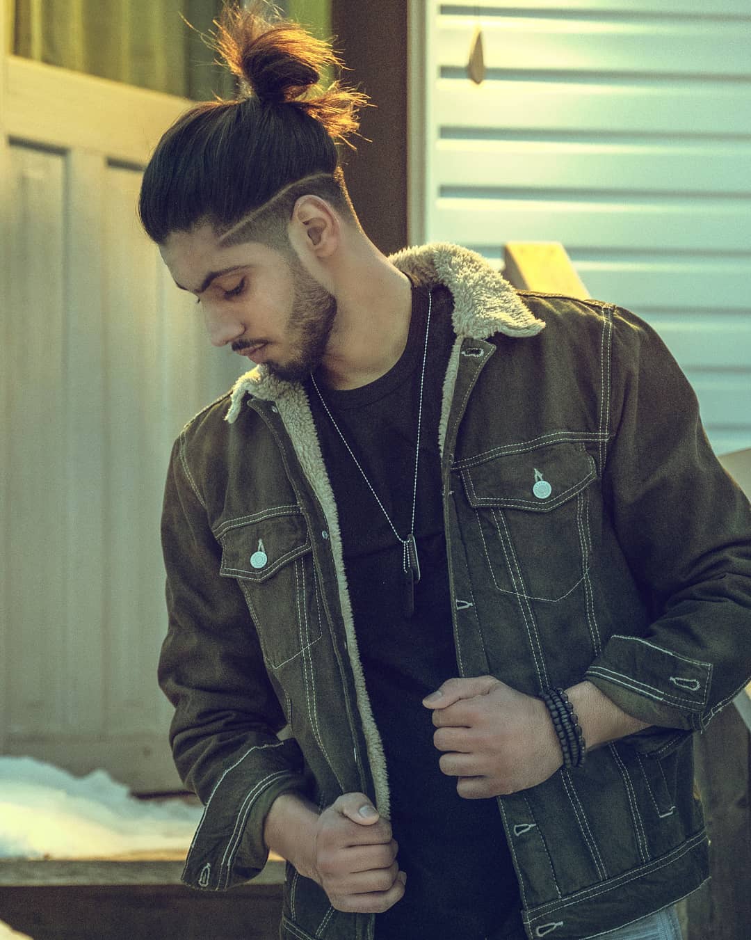 Brown haired man with a man bun with a disconnected fade