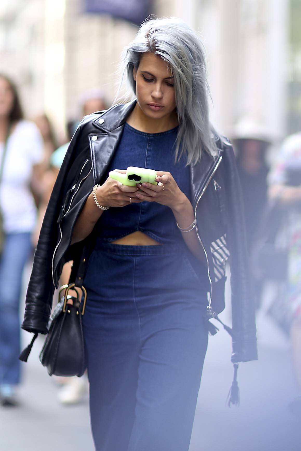 WHat causes grey hair woman on phone with grey hair walking down street