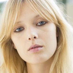blonde model with a rectangle face with 70s style parted bangs