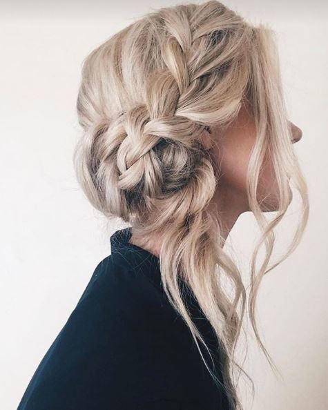 side view of blonde woman with hair in undone side bun with loose strands falling around the hairline