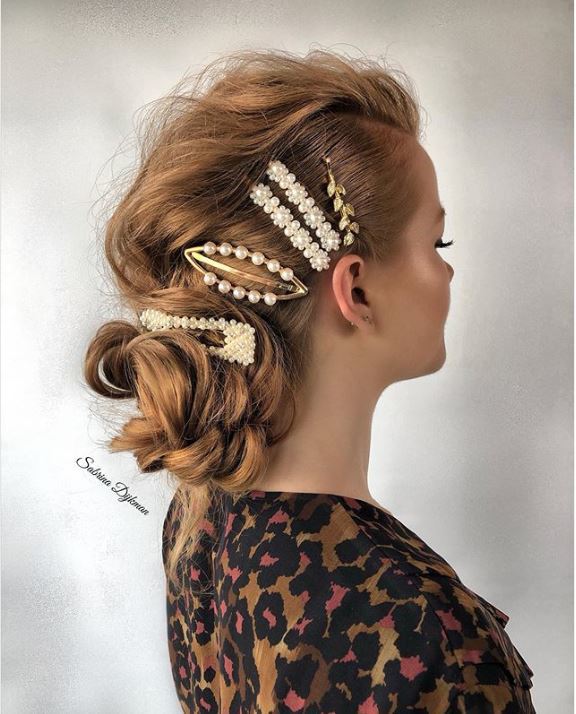 Woman with blonde hair in side bun with stacked hair clips