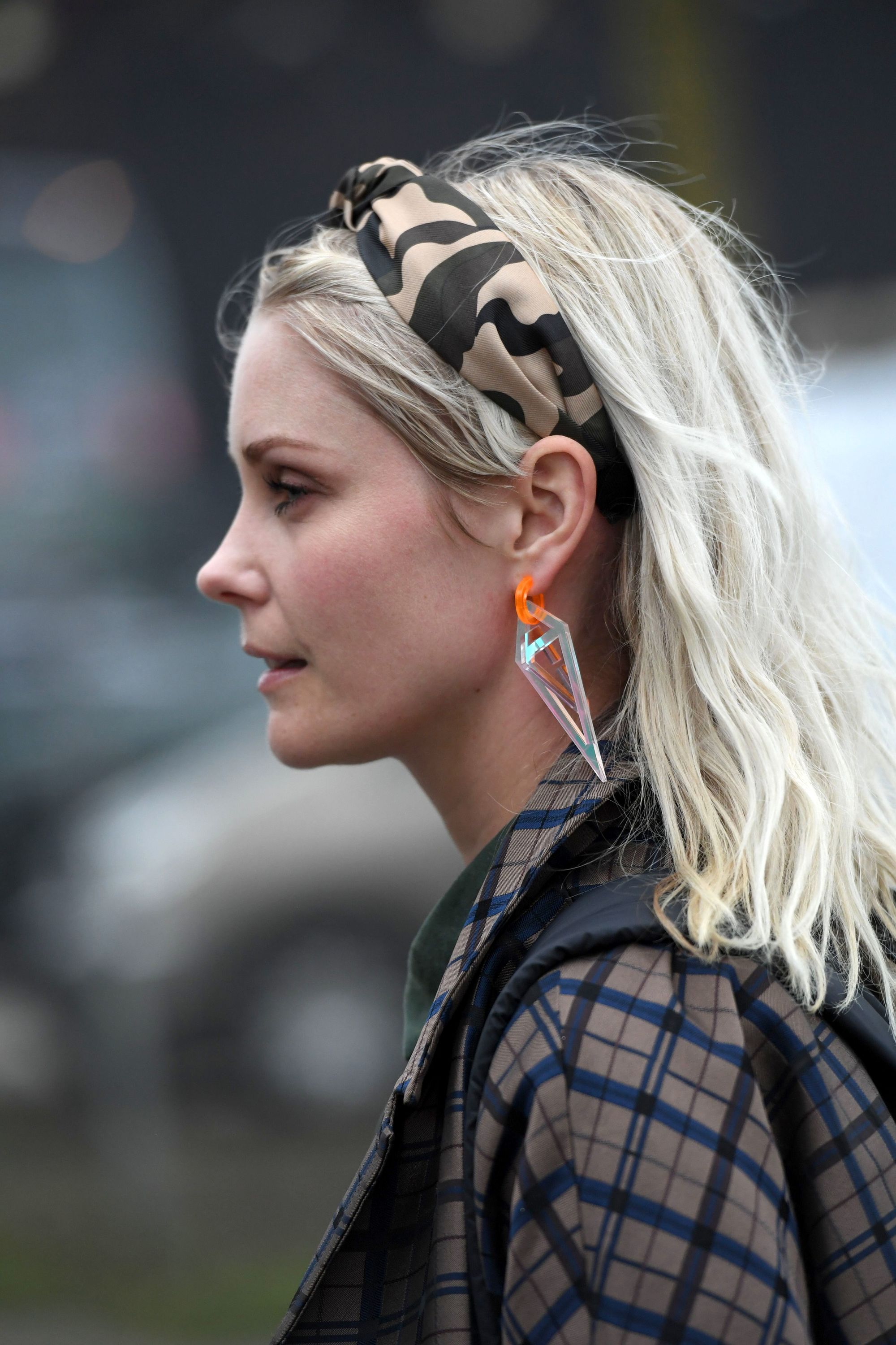 Spring haircuts: Side profile street style shot of a woman with mid length ash blonde hair with a camo leopard print headband