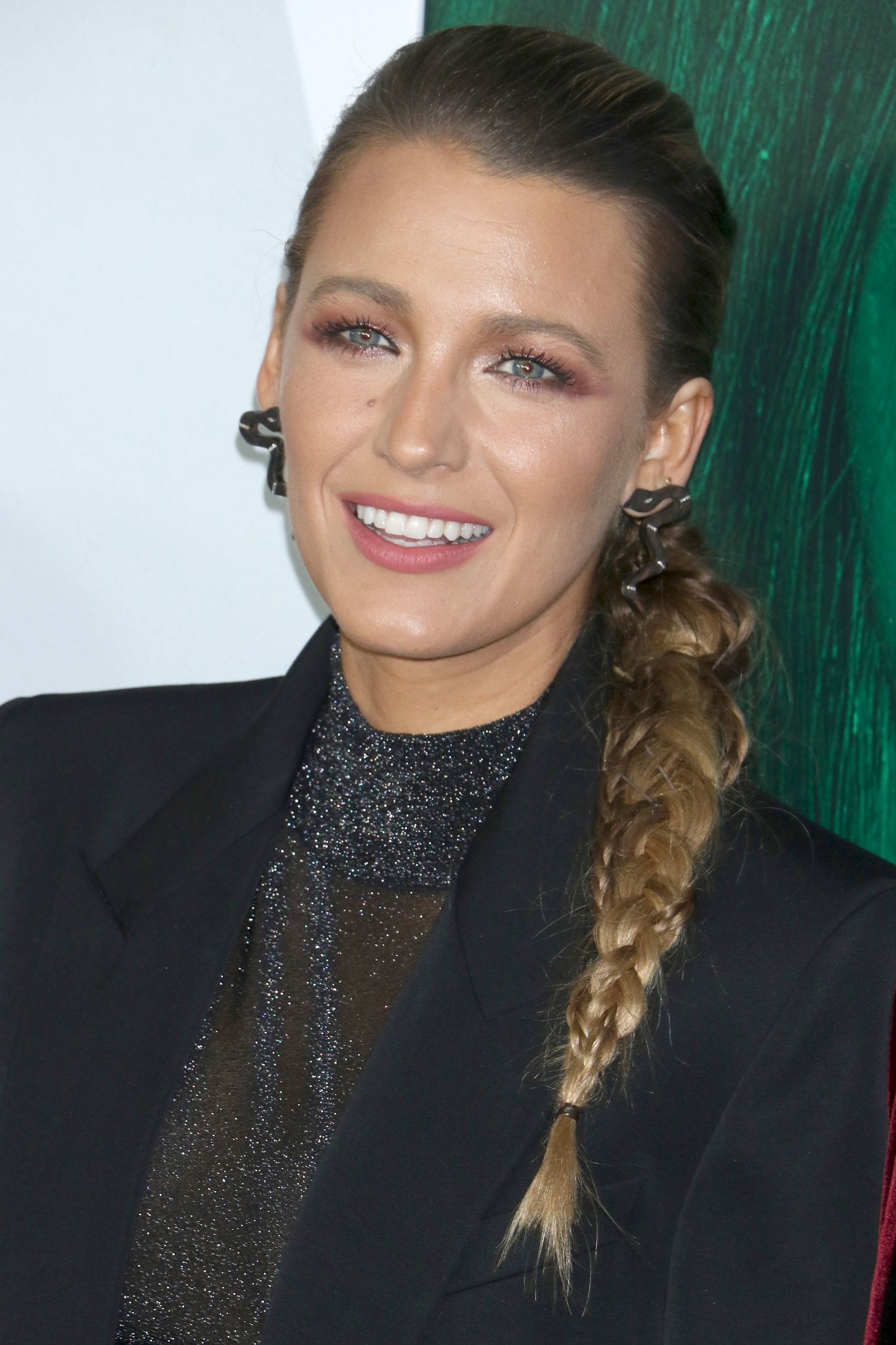 Side braid hairstyles: Blake Lively with long blonde side ponytail braid wearing a black outfit.