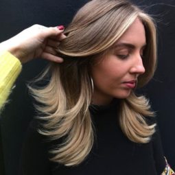 woman with chunky light brown and blonde highlights with flicked out ends