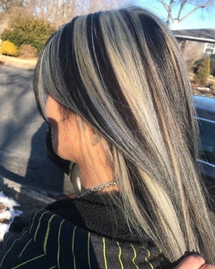 woman with straight long hair with black and silver blonde chunky highlights
