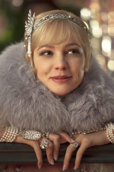 close up shot of carey mulligan as daisy buchanan, wearing a furry scarf, a flapper dress and a silver hairband hair accessory with pixie haircut, on the set of The Great Gatsby
