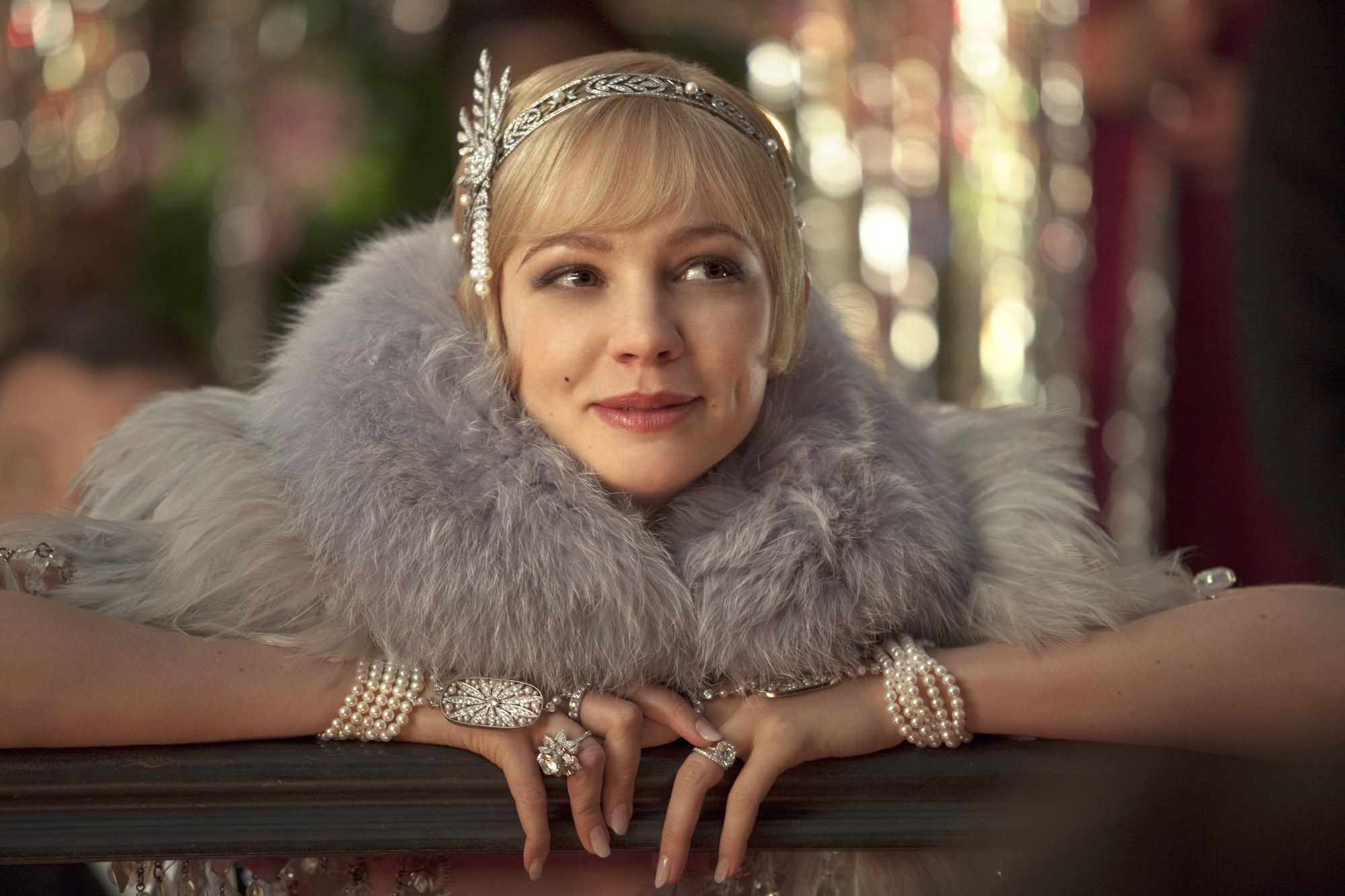 close up shot of carey mulligan as daisy buchanan, wearing a furry scarf, a flapper dress and a silver hairband hair accessory with pixie haircut, on the set of The Great Gatsby