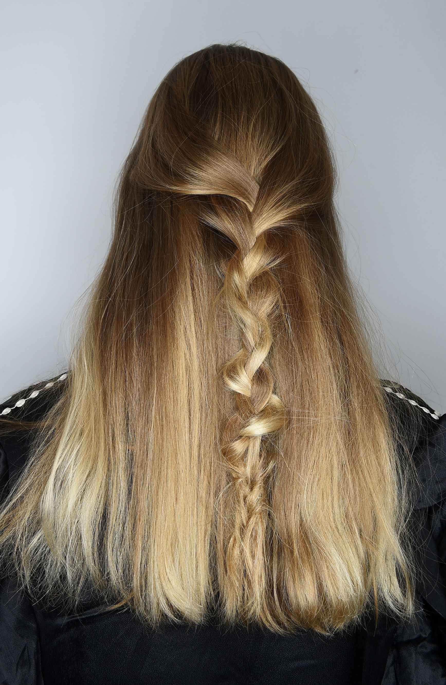 prom hairstyles: close up shot on model backstage with a half up half down twisted braid hairstyle