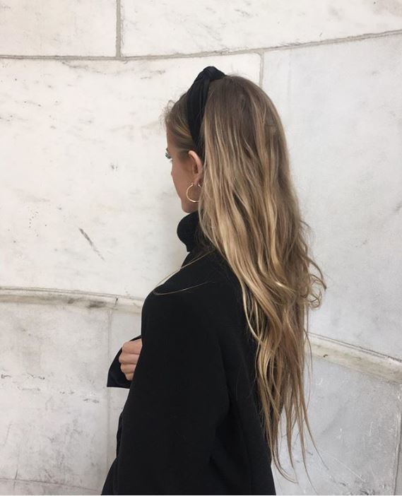 Second day hair: Woman with long wavy dirty blonde balayage hair wearing a headband.