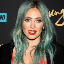 Green hair; Lizzie Mcguire actress Hilary Duff with green dyed long hair softly curled wearing a red plunging dress with a black jacket