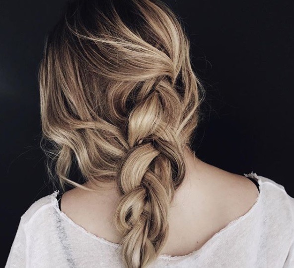 close up Instagram shot of with loose braided low ponytail, wearing all white and posing in studio